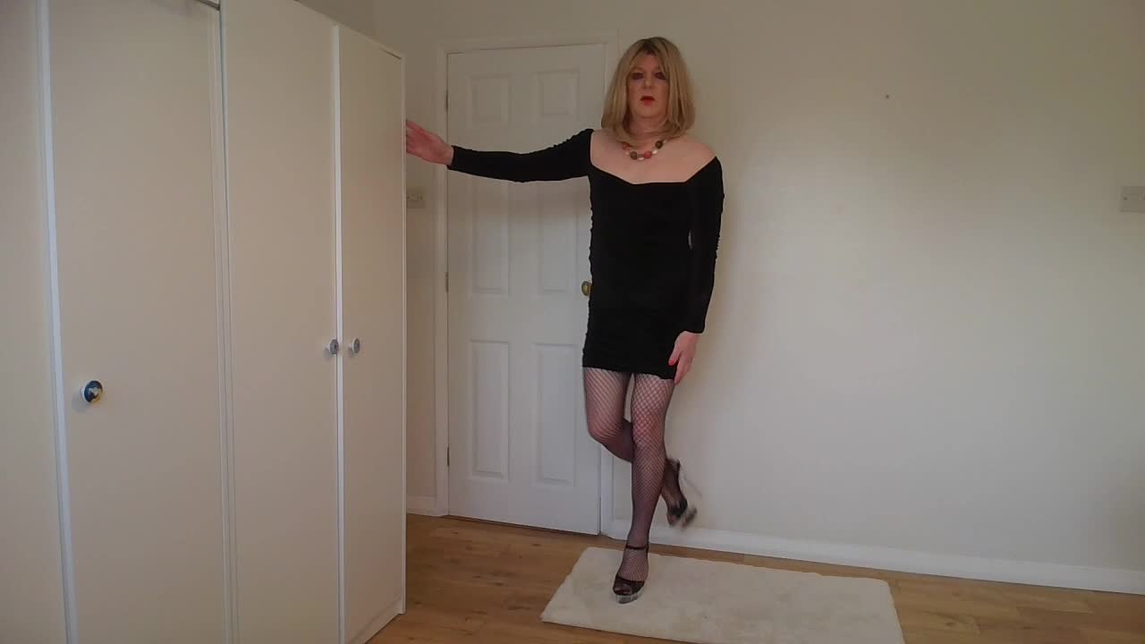 Cute blonde in little black dress, fishnets and heels